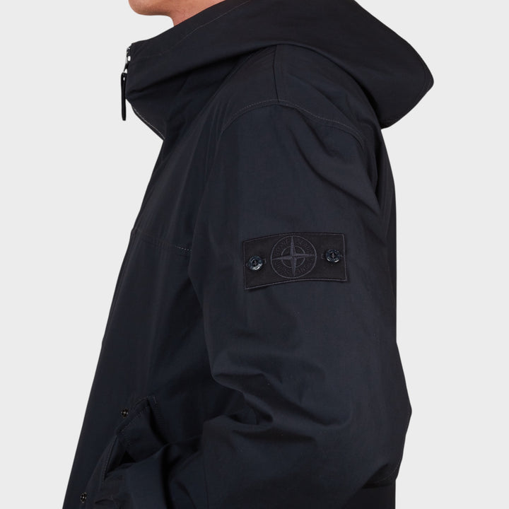 Close-up af tone-i-tone Ghost badge på Stone Island Jacket i Navy.
