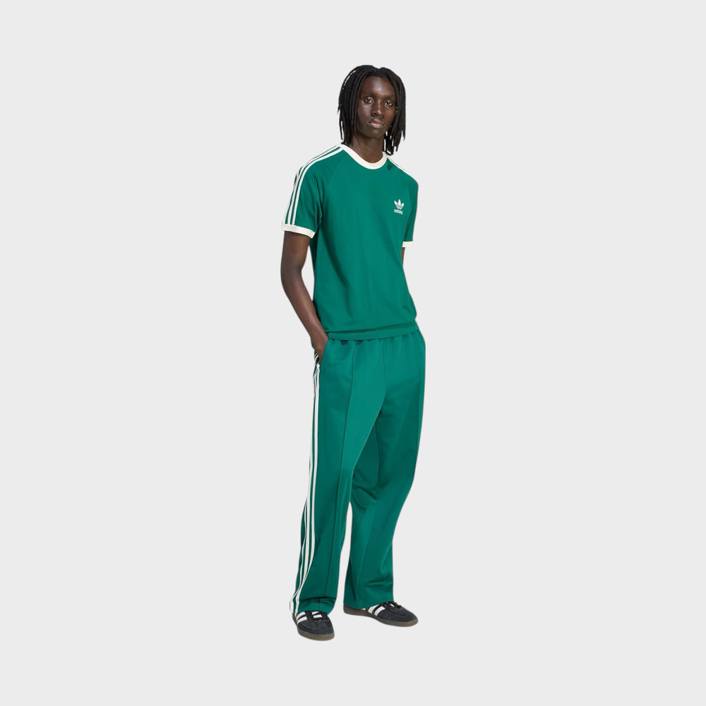 Adidas Baggy Trackpants i Collegiate Green set bagfra med et rent og moderne udtryk.