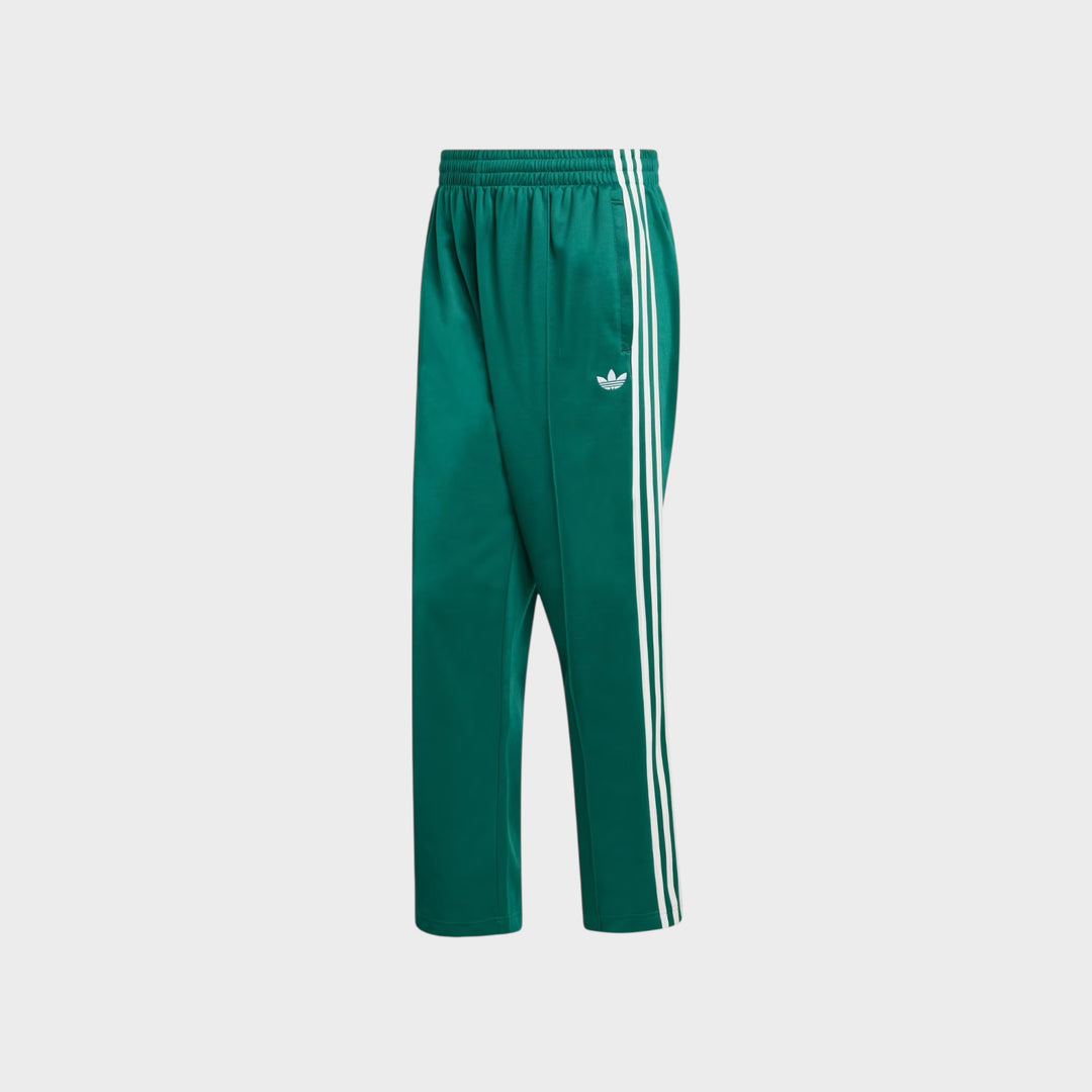 Detalje af Adidas Baggy Trackpants i Collegiate Green med ikoniske adidas-detaljer.