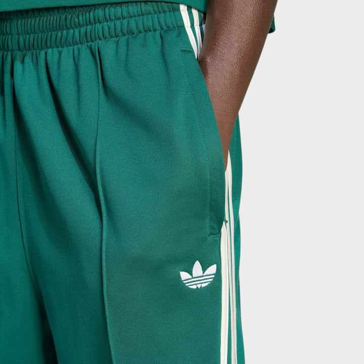Nærbillede af materialet på Adidas Baggy Trackpants i Collegiate Green med glat og behagelig kvalitet.