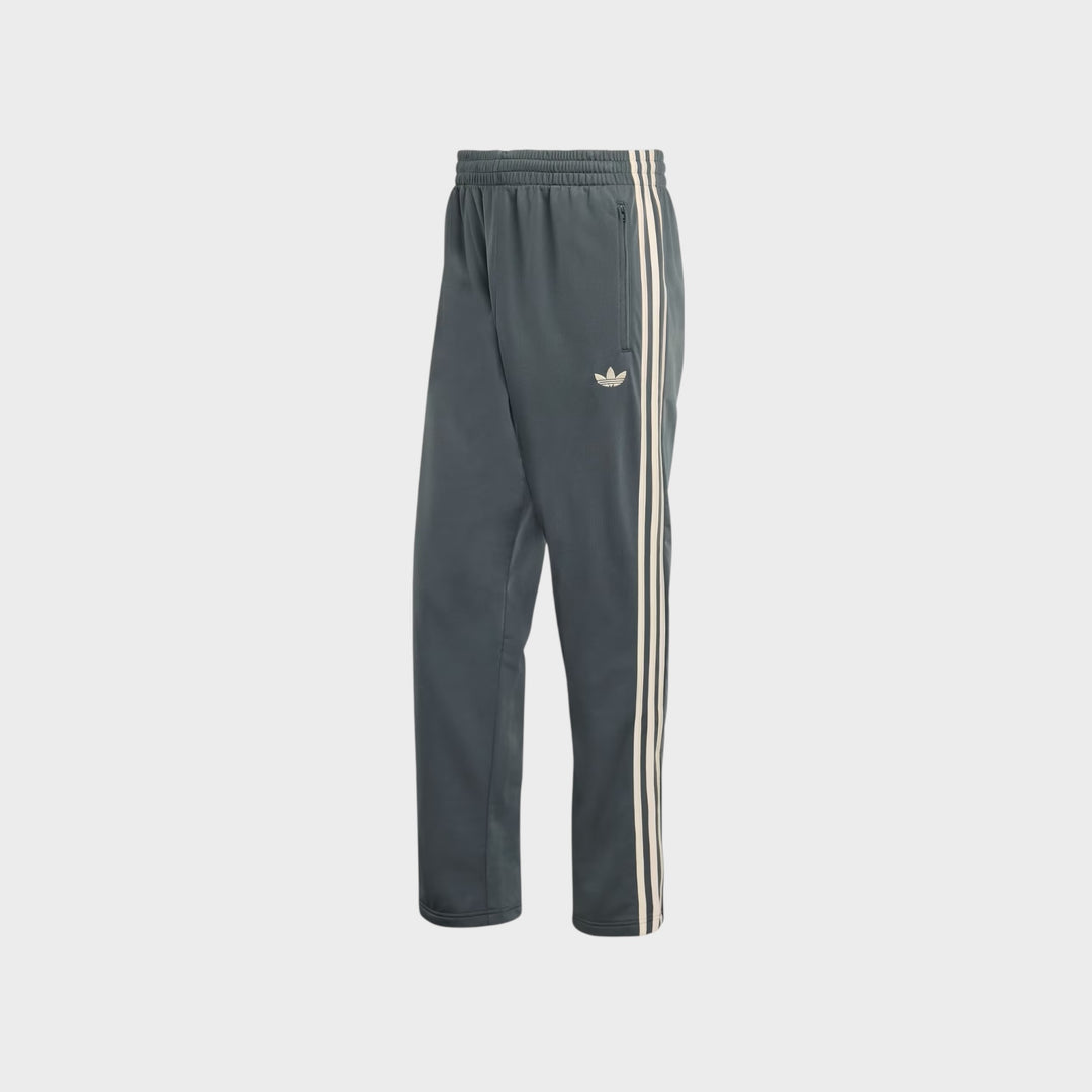 Detalje af Adidas Firebird Trackpants i Charcoal og Cream White med ikoniske adidas-detaljer.