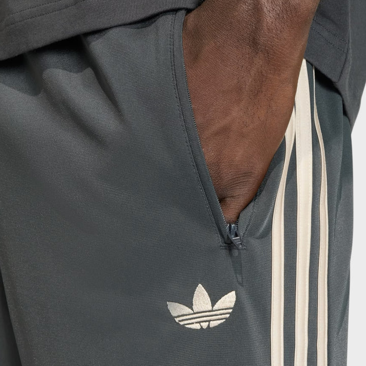 Adidas Firebird Trackpants i Charcoal og Cream White vist i helhed med regular fit og alsidig styling.