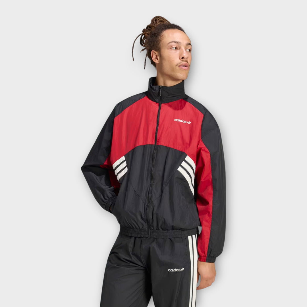 Adidas Originals tracktop med kontrastpaneler i sort og rød.
