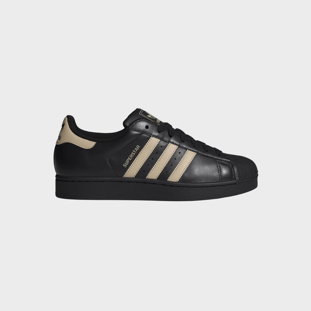 Adidas Superstar II sneakers i Core Black og Stone Khaki set forfra med ikonisk shell toe.