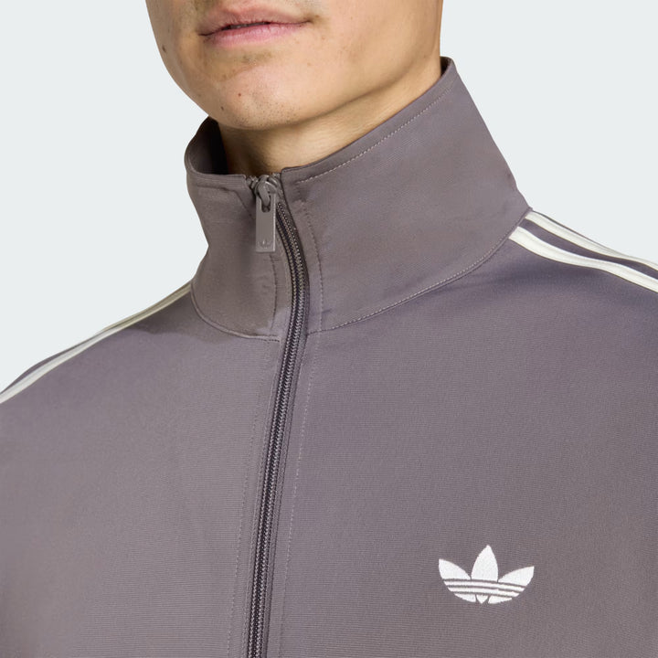 Detalje af Adidas Tracktop i Charcoal og Cream White med ikoniske adidas-detaljer og glat materiale.