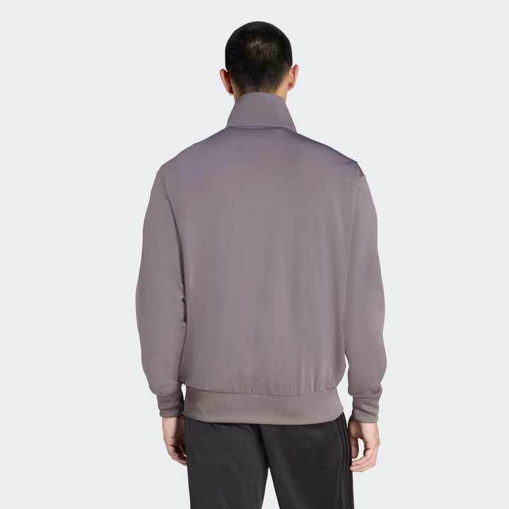 Nærbillede af materialet på Adidas Tracktop i Charcoal og Cream White med komfortabel og let kvalitet.