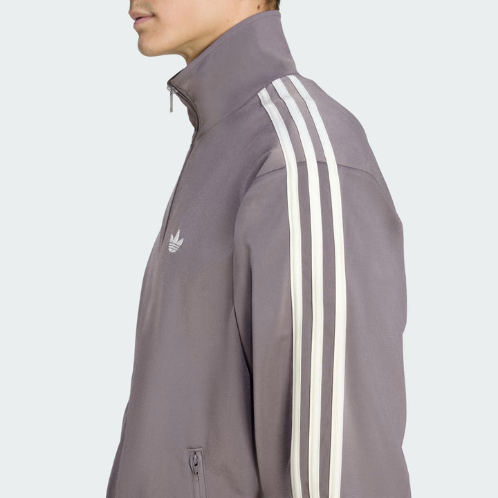 Lynlåslukning på Adidas Tracktop i Charcoal og Cream White med clean finish og funktionelt design.