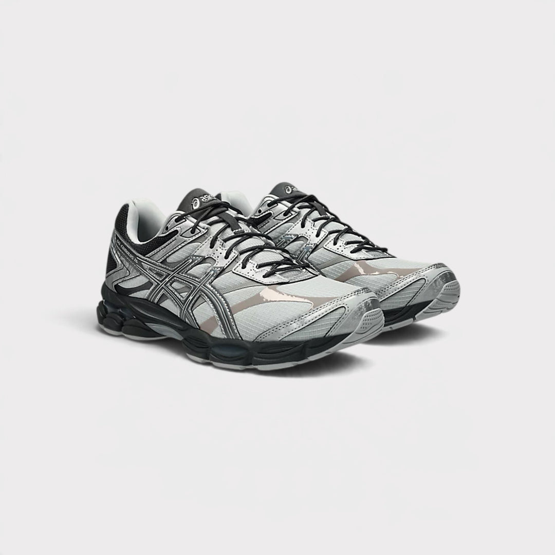 Et par Asics Gel-Cumulus 16 i Glacier Grey/Carbon set skråt forfra med mørke snørebånd.