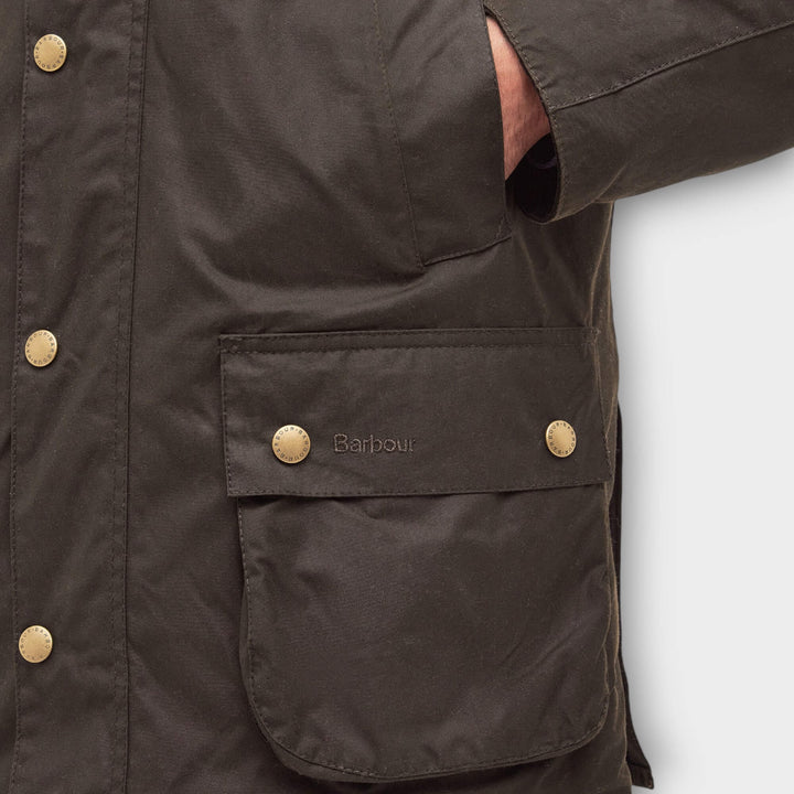 Detalje af klaplomme voksbomuld og Barbour-logo på Ashby Jakke i Olive