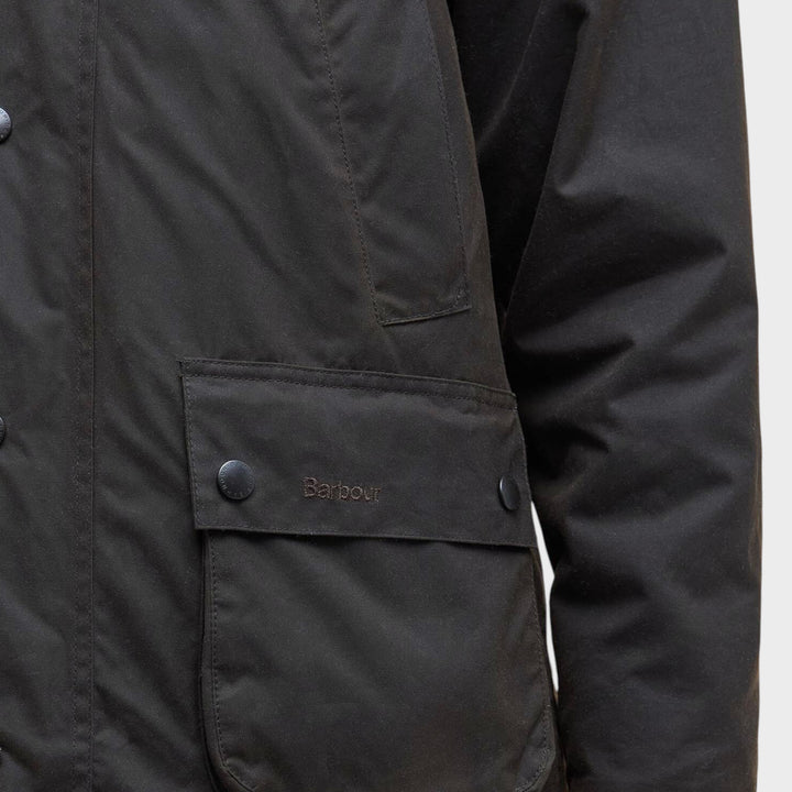 Close-up af bellow-lomme tonalt Barbour-logo og voksbomuld på Classic Bedale Jakke