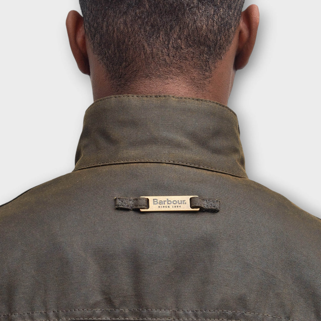 Close-up af Barbour-logo i nakken på Ogston Wax Jakke i Olive