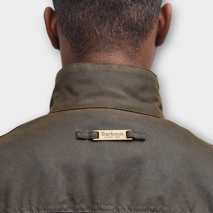 Close-up af Barbour-logo i nakken på Ogston Wax Jakke i Olive