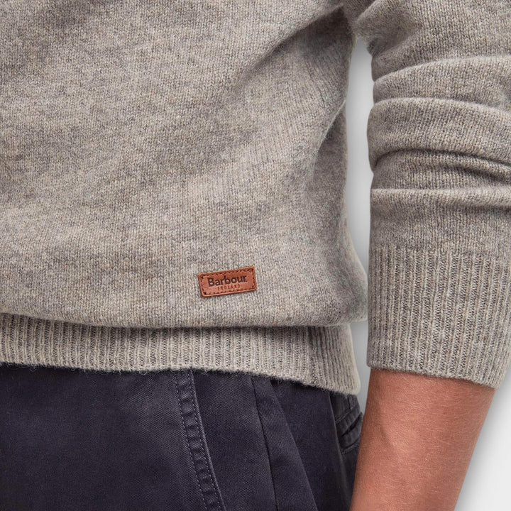 Close-up af Barbour-logo ribkant og uldstrik på Patch Strik i Sand