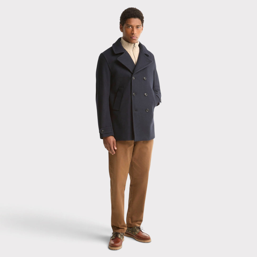 Barbour Polzeath Wool Pea Frakke i Navy – vist på model i helfigur med brune bukser