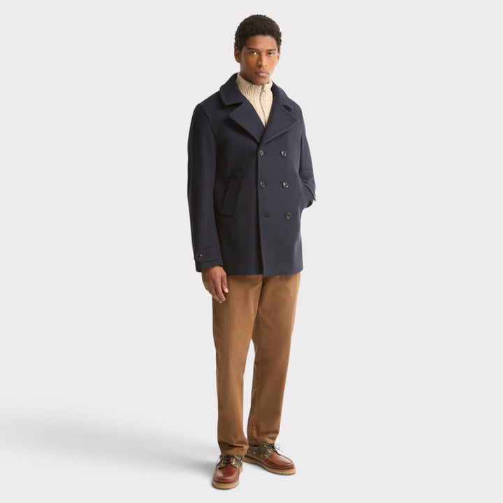 Barbour Polzeath Wool Pea Frakke i Navy – vist på model i helfigur med brune bukser
