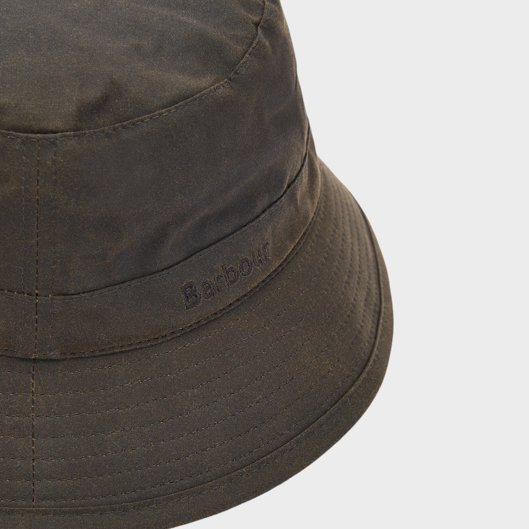 Close-up af broderet Barbour-logo og syninger på Wax Bucket Hat i Grøn