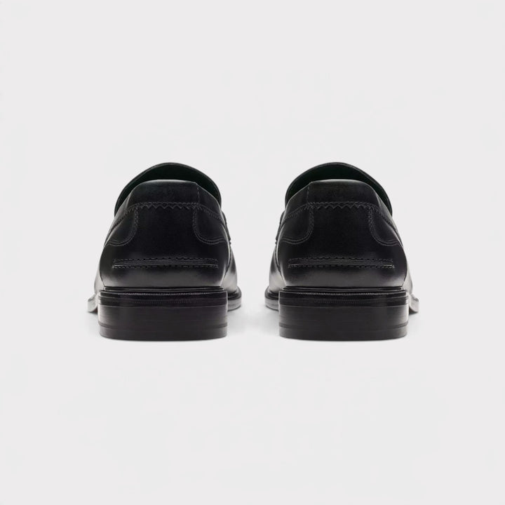 Clarks Craft James Lo i Black Leather vist som par bagfra med lave sorte hæle og syninger.