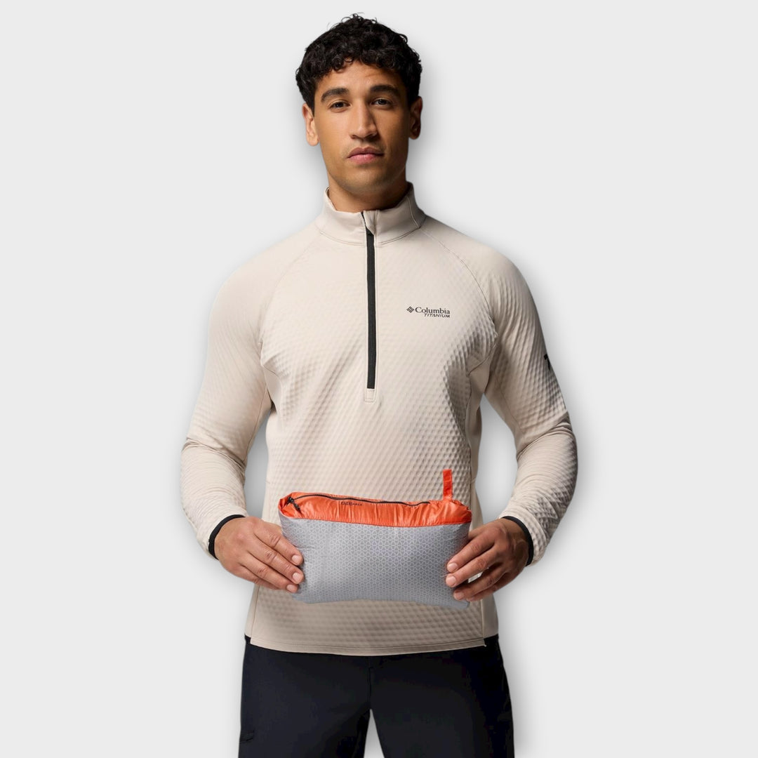 Detaljebillede af Columbia-logoet på brystet på Arctic Crest Down Hooded Jacket i Zing/Orange.