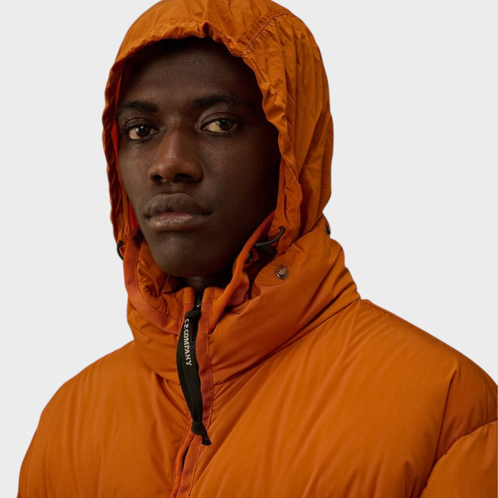 Nærbillede af materialet på C.P. Company Nycra-R Hooded Down Jacket i Russet Orange med glat og slidstærk overflade.