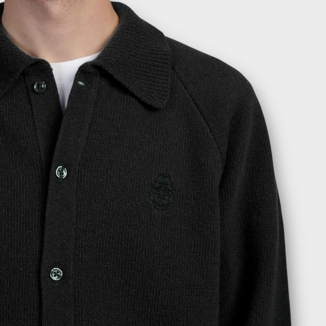 Detaljebillede af Edwin Mars Polo Cardigan i sort med struktur og logo.