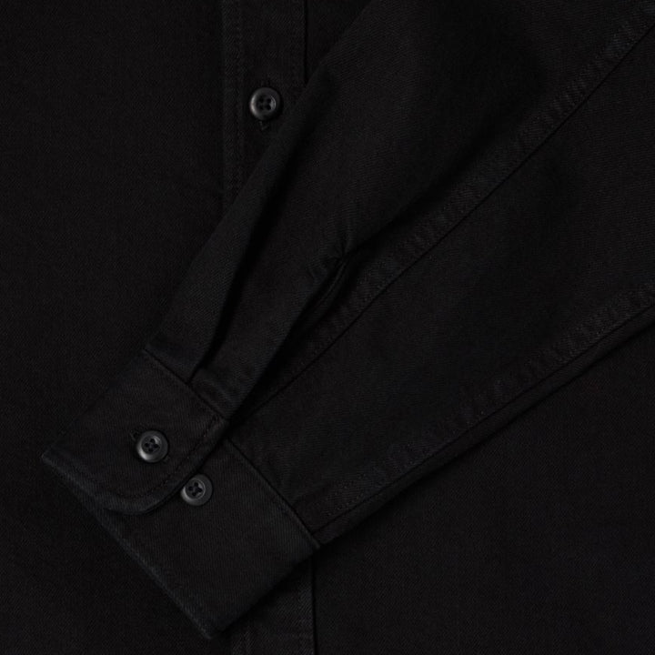 Detaljebillede af Edwin Sebastian Skjorte i sort med logo og struktur i stoffet.