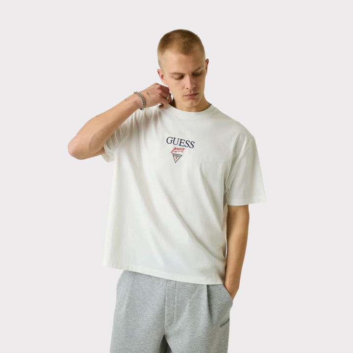 Guess Jeans Printed Logo T-Shirt i White – vist forfra på model med fokus på brystlogo og rund hals