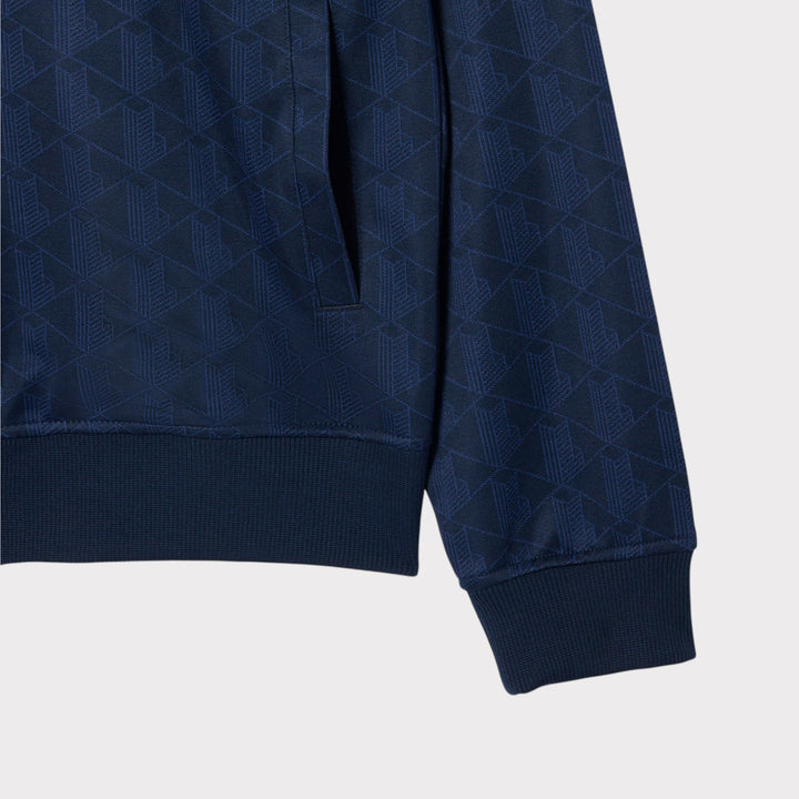 Nærbillede af sidelomme, manchet og ribkant på Lacoste Monogram Jacquard Zipped Jacket i navy