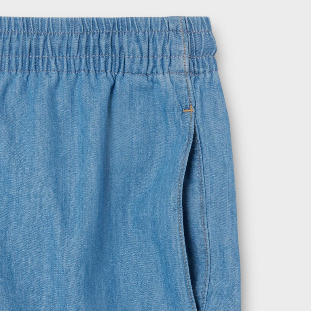 Detalje af Lacoste denim shorts med logo og denimstruktur