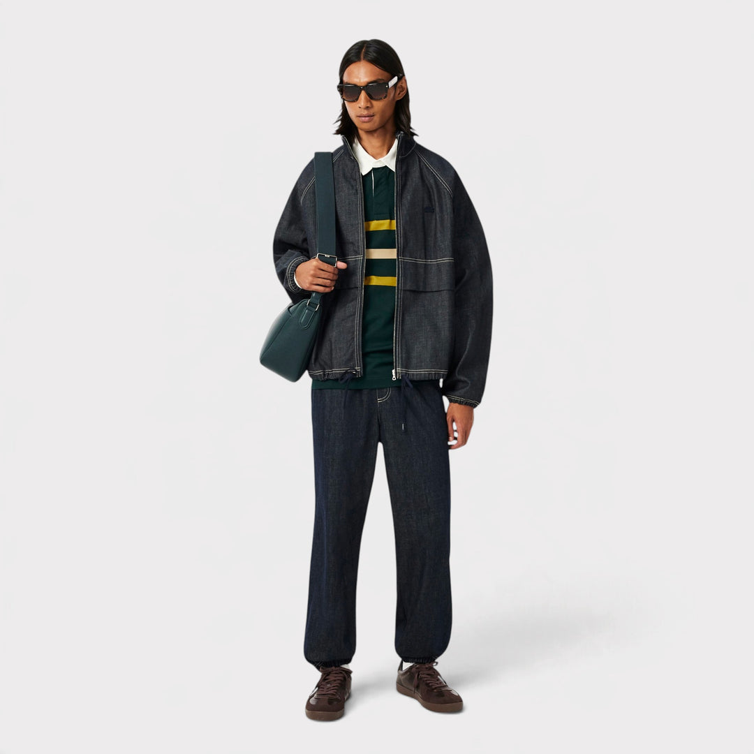 Lacoste Rugby Polo i Sinople på model i helfigur med mørk denimjakke, solbriller og taske