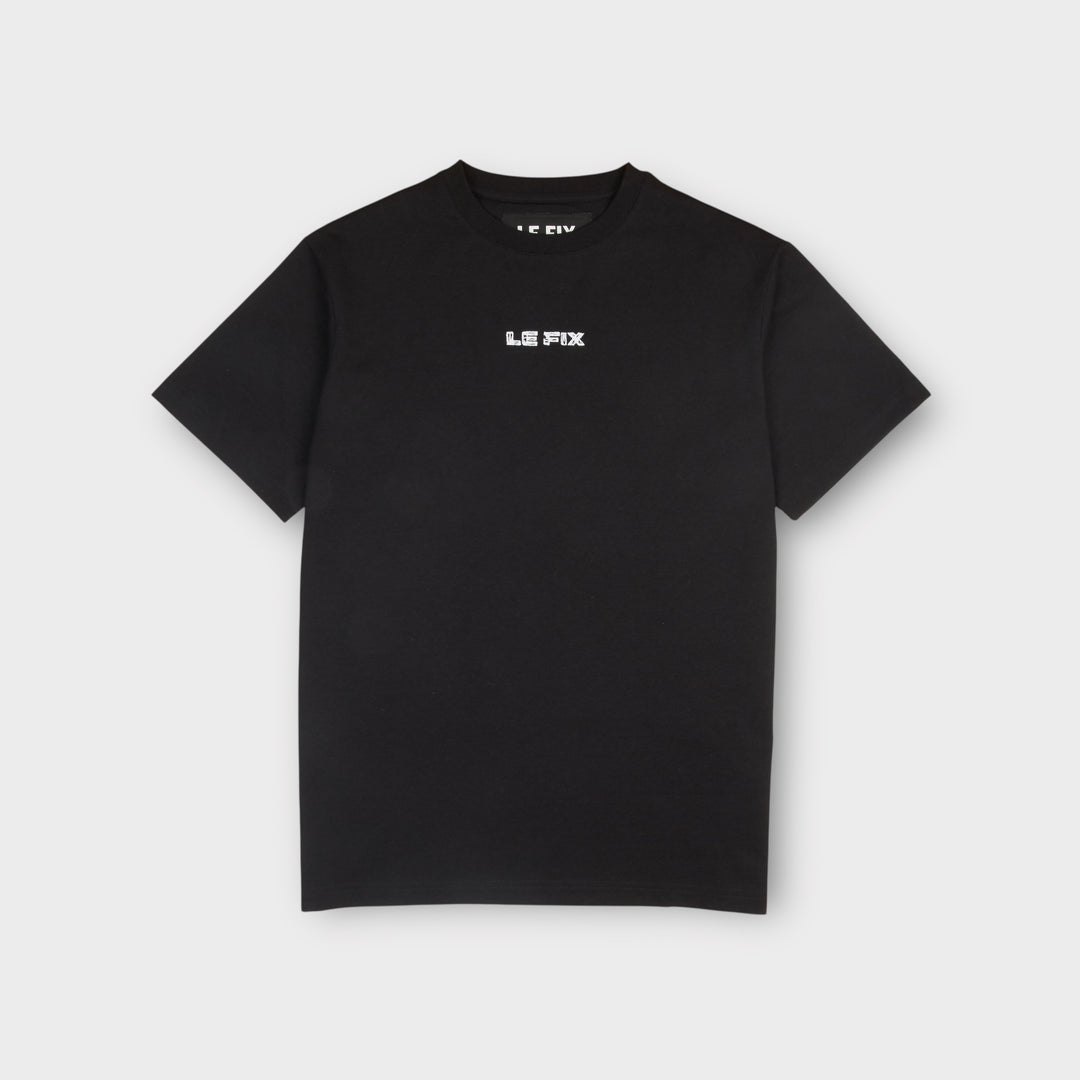Sort Le Fix Scratched T-shirt set forfra med pixeleret hvidt logo på brystet.