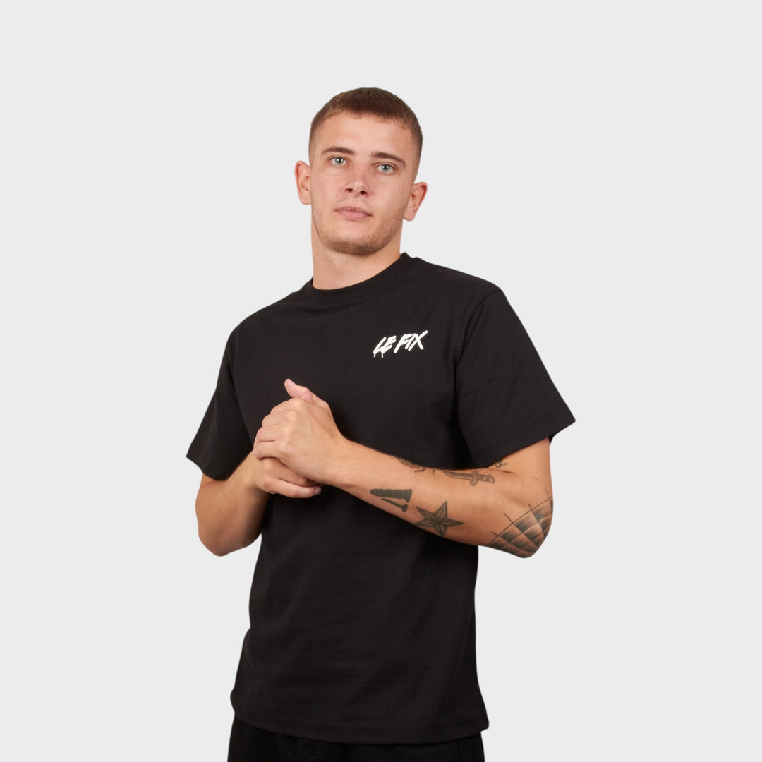 Model iført Le Fix spray t-shirt i sort