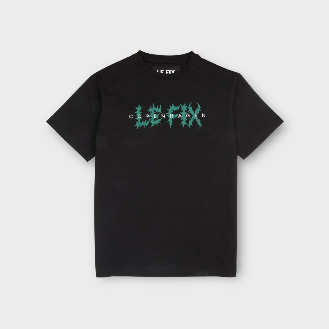 Le Fix Trash T-shirt i sort set forfra med grønt grafisk logo.