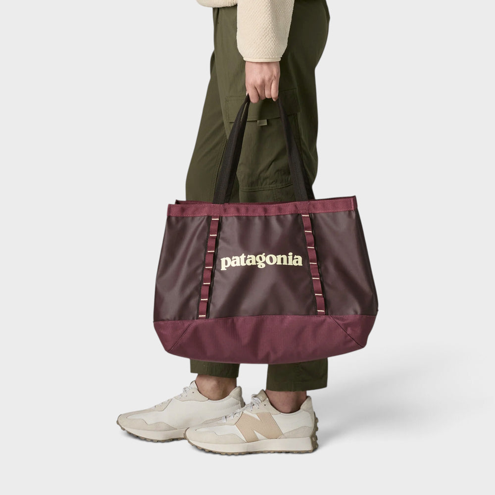 Patagonia Black Hole Tote 25L i  Berry Fig, båret i hånden på model