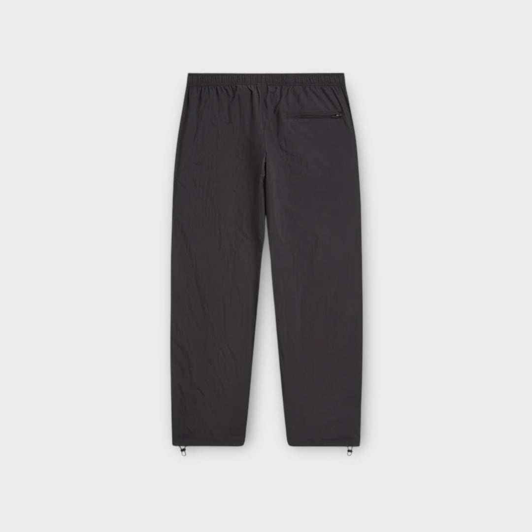 Broderet Patta-logo på låret af sorte trackbukser