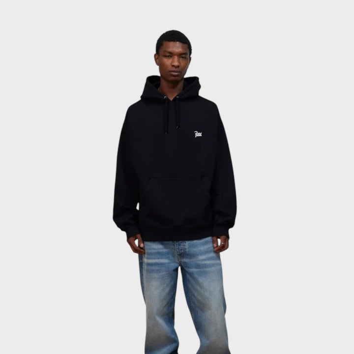 Patta Championship Hoodie i Sort vist forfra på model med Patta-logo på brystet