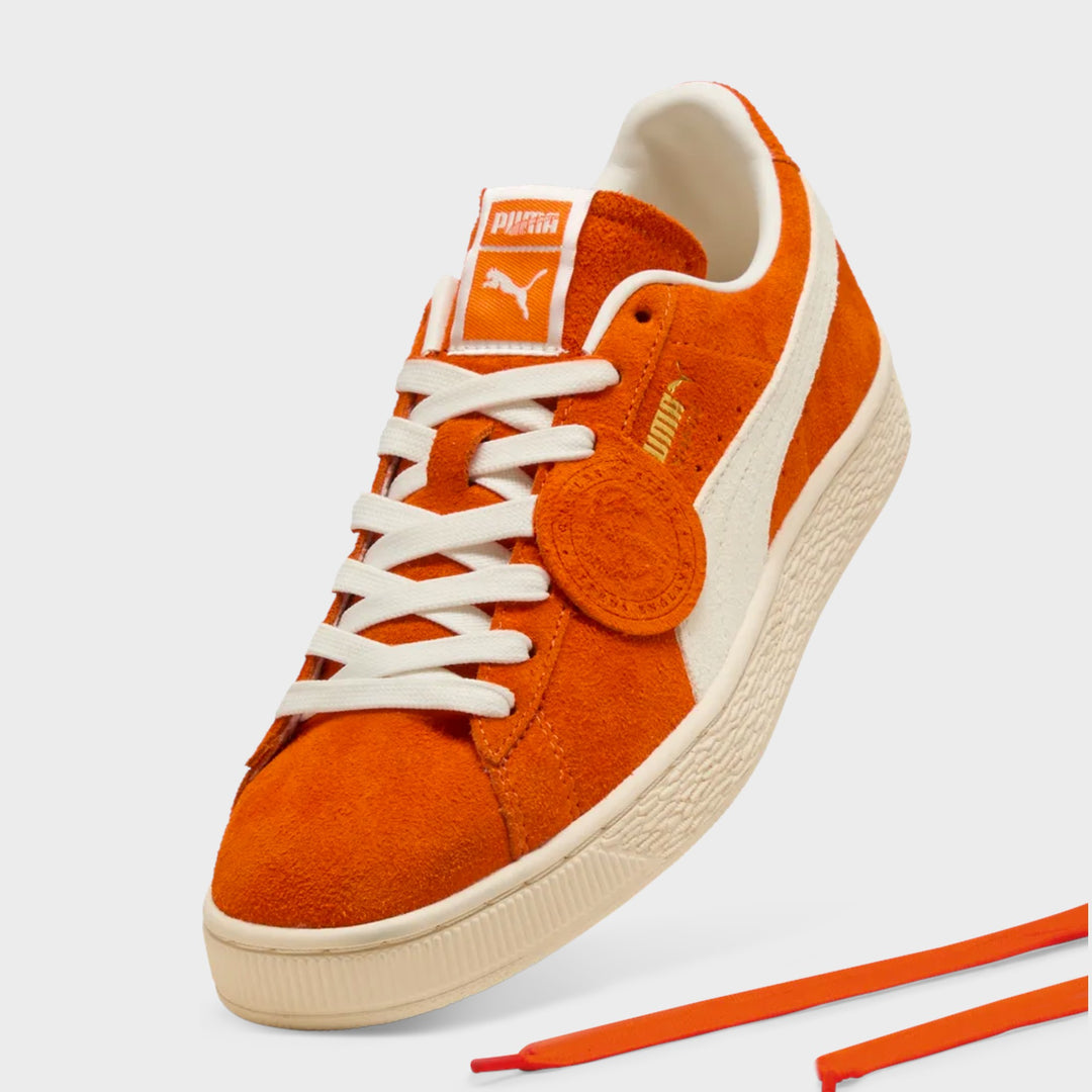 Puma Suede Charles F. Stead IV i orange og hvid, set fra siden i en tredje vinkel