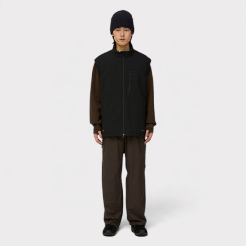 Snow Peak Breathable Insulated Vest i sort på model i helfigur med sort hue og brune bukser