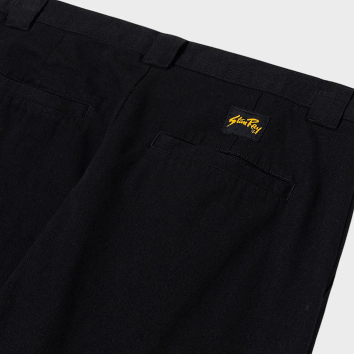 Skråt nærbillede af linning, bæltestropper, baglomme og logomærke på Stan Ray A Pant i Black Canvas
