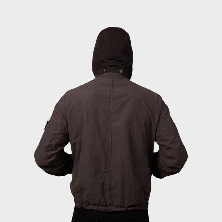 Model iført Stone Island David Light-TC med hætten oppe I Lead Grey jakke set fra bagsiden.