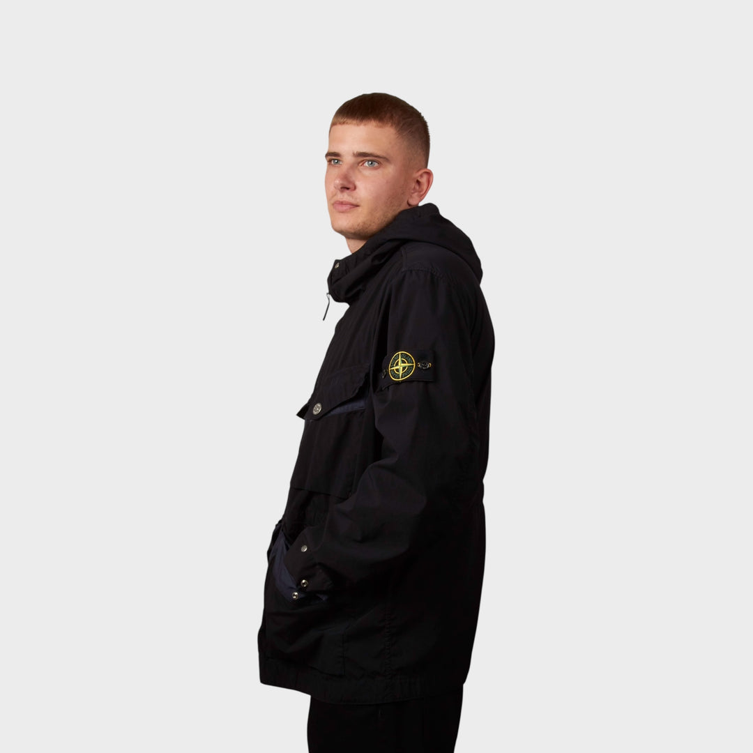 Model iført Stone Island Light Compact Touch Poly-TC Jakke i navy set fra siden.