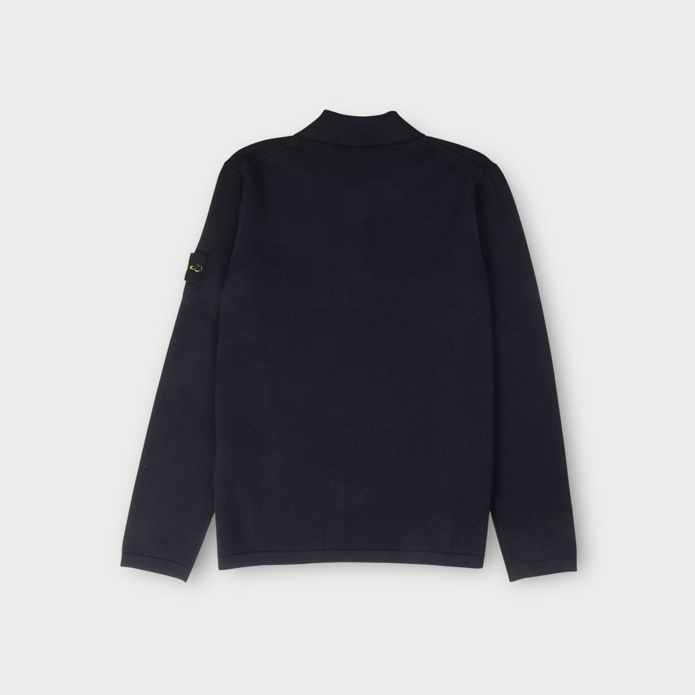 Detalje af Stone Island navy strikpolo med ribkanter og micro stitch struktur.